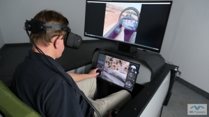 Flying in MVRsimulation's Part Task Mission Trainer (PTMT) wearing the Varjo XR-3 mixed reality headset. VRSG renders the out-the-window view in the headset and on the curved display. (Notice the pilot's hand on the controls is visible in the VRSG view.)